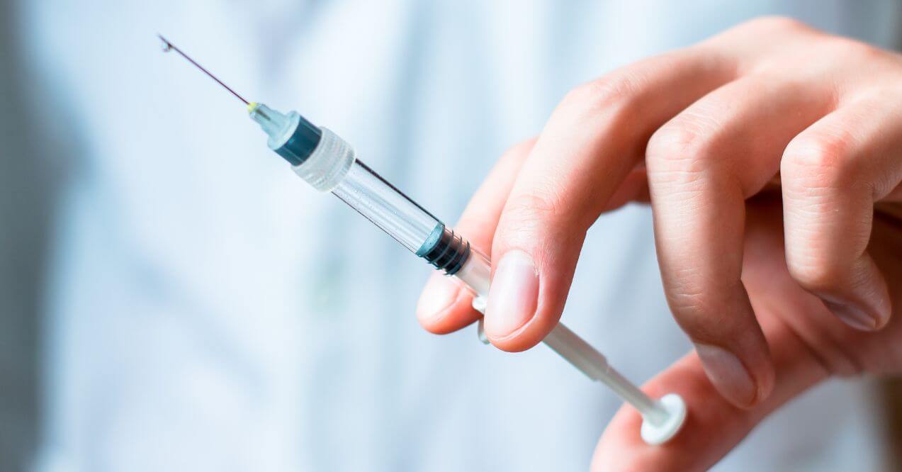 Close-up of facet joint injection with syringe and gloves