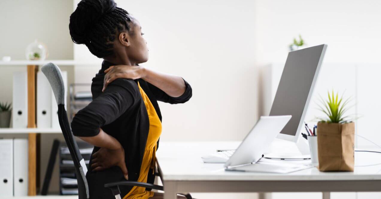 Woman at desk stretching due to back and neck pain