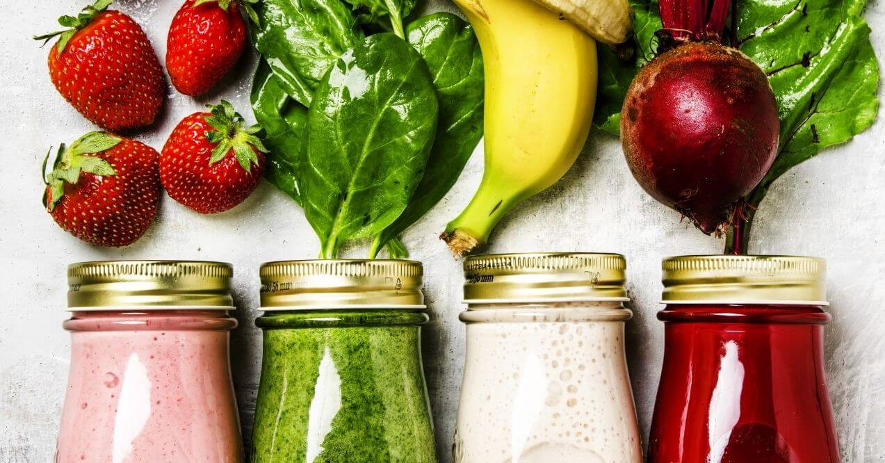 Different kinds of anti inflammatory smoothie with fresh fruits and leafy greens in jars
