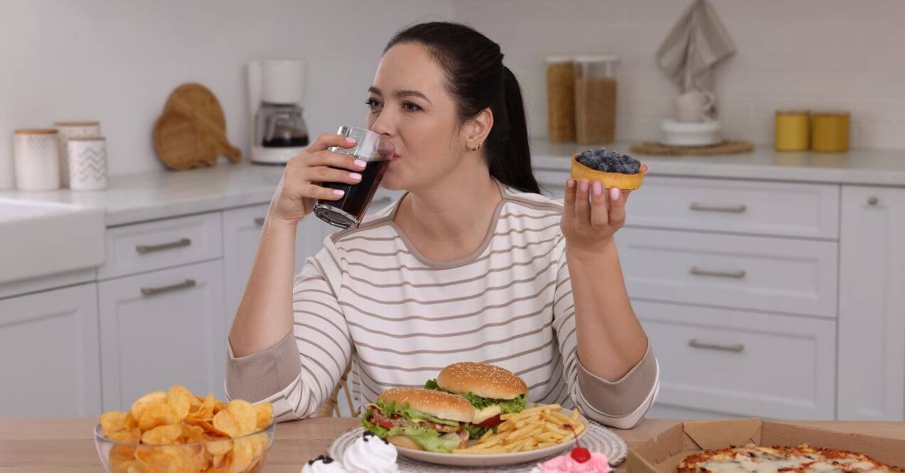 Woman eating worst foods for eye health in a kitchen setting.
