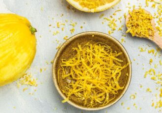 Grated lemon peel in a bowl resembling lemon peels to help with lymphatic drainage.